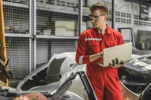 Old used car part warehouse worker checking inventory in garage. Staff worker working in recycle motor junkyard auto parts management. photo