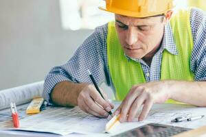 Architect Engineer Builder, Building Designer working with floorplan at Construction Site. photo