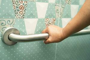 asiático mayor mujer utilizar baño encargarse de seguridad en baño, sano fuerte médico concepto. foto