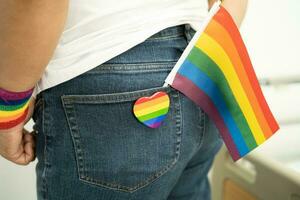 Woman holding LGBT rainbow colorful flag, symbol of lesbian, gay, bisexual, transgender, human rights, tolerance and peace. photo