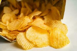 papas fritas, delicioso condimento para barbacoa picante para crips, bocadillo frito de rebanada fina, comida rápida en bolsa abierta. foto