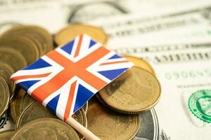 Stack of coins with United Kingdom flag and US dollar banknotes. photo