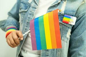 Woman holding LGBT rainbow colorful flag, symbol of lesbian, gay, bisexual, transgender, human rights, tolerance and peace. photo