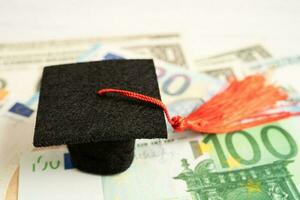 Sombrero de brecha de graduación en billetes de euro y dólar estadounidense, concepto de enseñanza de aprendizaje de tarifa de estudio de educación. foto