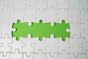 Jigsaw puzzle on green background, business teamwork, problem solving concept. photo