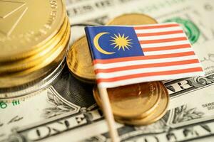 Stack of coins with Malaysia flag and US dollar banknotes. photo