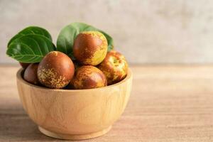 Jujube fruit or Chinese Dates in wooden bowl, healthy food. photo