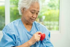 Doctor holding a red heart in hospital, healthy strong medical concept. photo