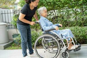 Caregiver help and care Asian senior woman patient sitting on wheelchair to ramp in nursing hospital, healthy strong medical concept. photo