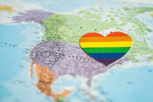 Bangkok, Thailand, June 1, 2022 Rainbow color heart on USA America globe world map background, LGBT pride month. photo