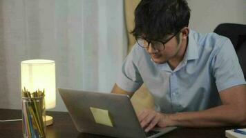 asiático hombre trabajando en línea con ordenador portátil a hogar oficina, teletrabajo concepto. video