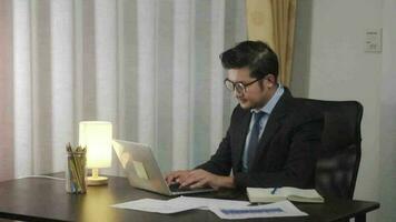 ásia homem de negocios trabalhando em computador portátil computador às casa escritório, trabalhando às casa em a Internet. video