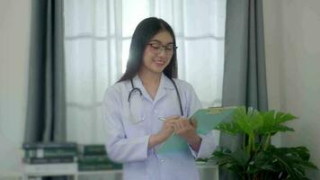 professionnel asiatique femme médecin examiner rapport document de patient à plan le suivant traitement. video