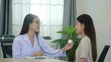 hermosa asiático mujer examina joven paciente. video