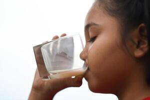 Little girl drinking milk in the park photo