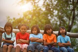 Group of sad kids sitting on the park photo