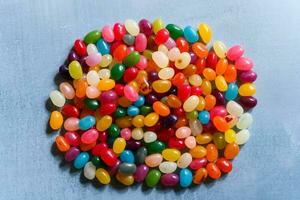 Big round pile of colorful jellybeans on rustic grey background photo