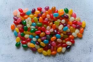 Big round pile of colorful jellybeans on rustic grey background photo