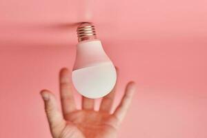 Light bulb and hand, idea catching concept. Symbol of new events or finding solutions to problems. Creative minimal innovations. photo