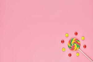 Sweet lollipop and candy on pink background photo