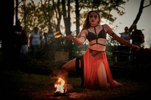 niña fuego bailando actuación a al aire libre Arte festival, suave movimientos de hembra artista foto
