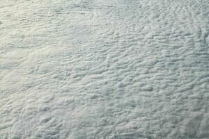 impresionantes vistas de las nubes desde la ventana del avión, gruesas nubes blancas azules parecen espuma blanda foto