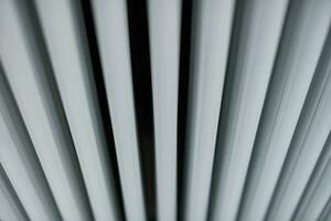 Heating radiator in office, close up. White heat exchangers. Iron aluminium steam radiator. Pipe pattern. photo