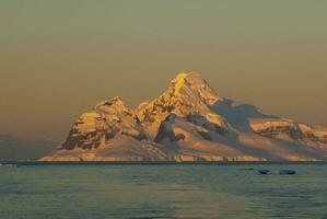 Lemaire strait coastal landscape, mountains and icebergs, Antarctic Peninsula, Antartica. photo