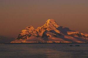 Lemaire strait coastal landscape, mountains and icebergs, Antarctic Peninsula, Antartica. photo