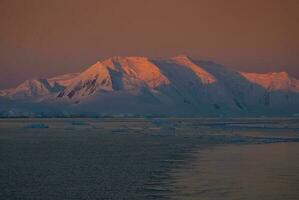 Lemaire strait coastal landscape, mountains and icebergs, Antarctic Peninsula, Antartica. photo