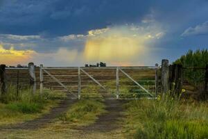 Countryside gate Stormy with a stormy sky in the background, La Pampa province, Patagonia, Argentina. photo