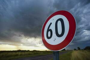 Maximum speed road sign with a stormy sky background, La Pampa province, Patagonia, Argentina. photo