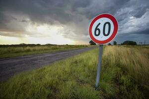 Maximum speed road sign with a stormy sky background, La Pampa province, Patagonia, Argentina. photo