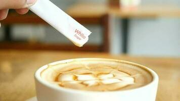 a person is pouring white sugar in a cup of coffee video