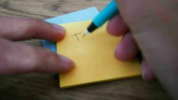 Man writing Thanks note on yellow paper note with blue pen and soft focus scene. video