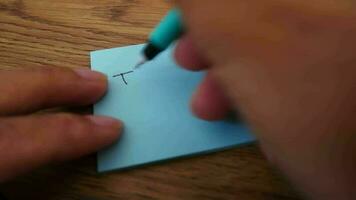 homem escrevendo viaja Nota em azul papel Nota com azul caneta e suave foco cena. video