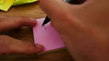 homem escrevendo imposto 2023 Nota em amarelo papel Nota com Preto caneta e suave foco cena. video