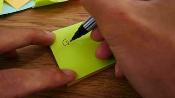 Man writing Great job note on yellow paper note with black pen and soft focus scene. video