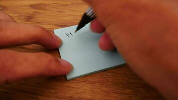 Man writing have a productive week note on yellow paper note with black pen and soft focus scene. video