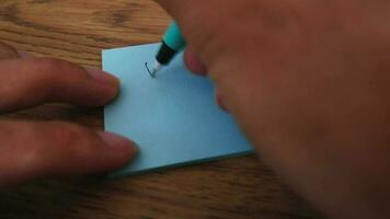 Mann Schreiben danken Sie Hinweis auf Blau Papier Hinweis mit Blau Stift und Sanft Fokus Szene. video