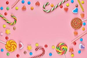 Sweet candy copy space frame with lollipops on pink background photo