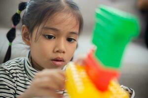 Adorable little girl playing toy blocks in a bright room photo