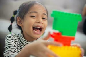 Adorable little girl playing toy blocks in a bright room photo