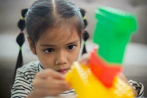 Adorable little girl playing toy blocks in a bright room photo