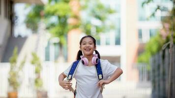 Back to school. Cute Asian child girl with a backpack running and going to school with fun photo