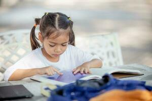 Back to school. Asian girl reading a book. Primary school students after classes learning homework. photo