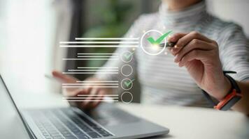 Businesswomen do online checklist surveys, Checkmarks on checklists, and fill out online forms or answer questions. Business performance checklist, evaluation, online survey, and online exams. photo