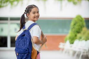 Back to school. Cute Asian child girl with a backpack running and going to school with fun photo