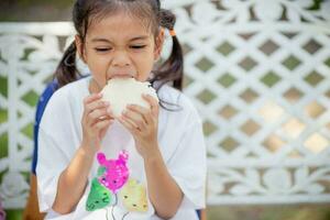 linda Chica de escuela comiendo al aire libre el escuela. sano colegio desayuno para niños. comida para almuerzo. foto