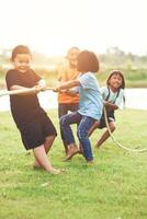 Children group playing tug of war at the park photo